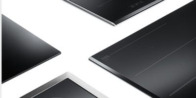 Großes Induktionskochfeld mit integriertem Lüfter auf weißer Arbeitsplatte.